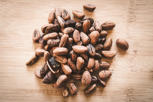 Raw cocoa beans on a wooden board