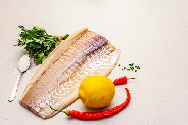 Raw cod loin fillet with lemon, sea salt, chili and cayenne pepper, parsley