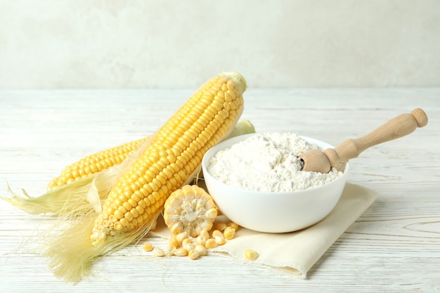 Raw corn and flour on white wooden table