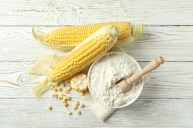 Photo raw corn and flour on white wooden table