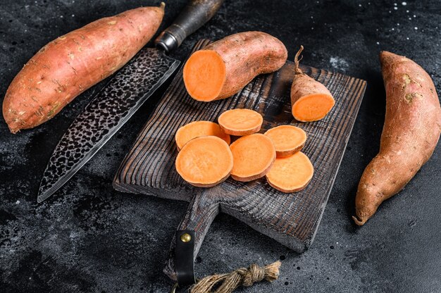 Raw cut batata Sweet potato on Wooden cutting board.