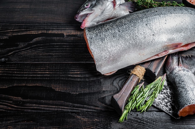 Raw cut salmon fish on a wooden cutting board with chef cleaver