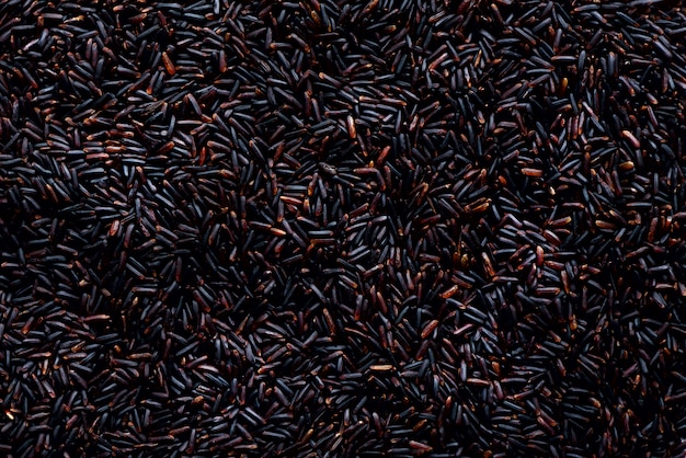 Raw dark red, balck purple rice, texture. Riceberry pattern. Food ingredient. Top view, healthy lifestyle concept.