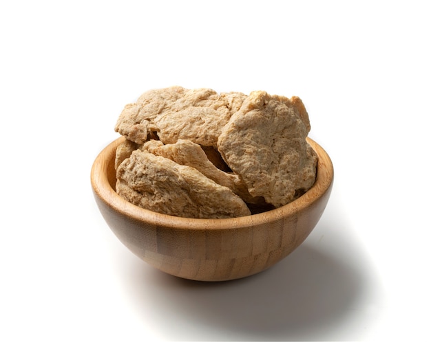 Raw dehydrated soy meat or soya chunks in wood bowl isolated. Texturized vegetable protein, also known as textured soy protein or TSP