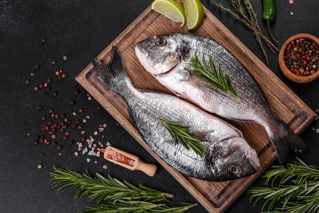 Raw dorado fish with spices cooking on cutting board. Fresh fish dorado. Dorado and ingredients for cooking on a table