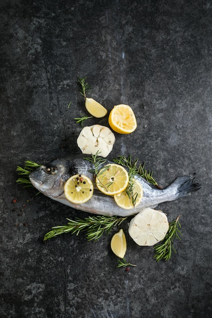 Raw dorado fish with spices Dorado and ingredients for cooking on a table