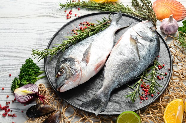 Raw dorado fish with spices On a white wooden background Top view