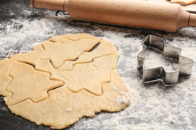 テーブルの上の生の生地とクリスマスのクッキー