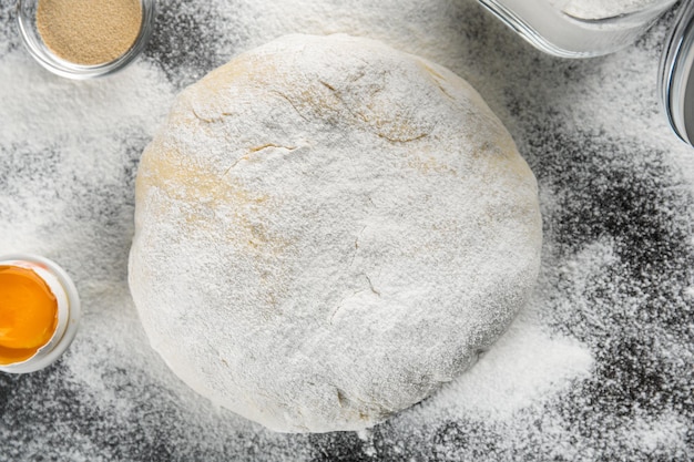 Raw dough sprinkled with flour on table