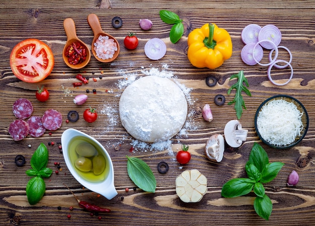 Raw dough with ingredients for homemade pizza 