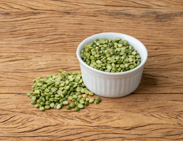 raw dried green peas in a bowl over wooden table