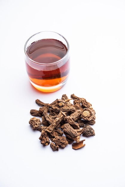 Photo raw dried indian ayurvedic sarsaparilla or anantmool with kadha drink or tea