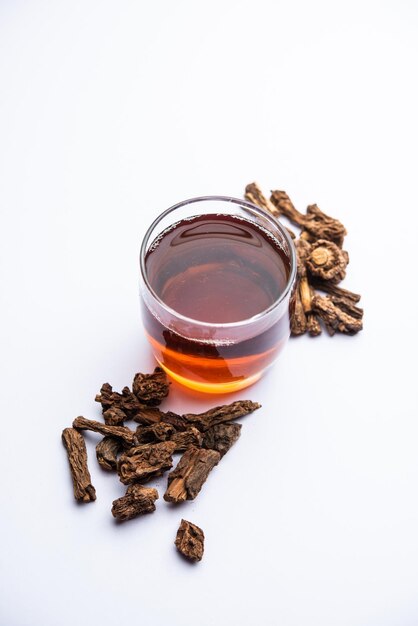 Photo raw dried indian ayurvedic sarsaparilla or anantmool with kadha drink or tea