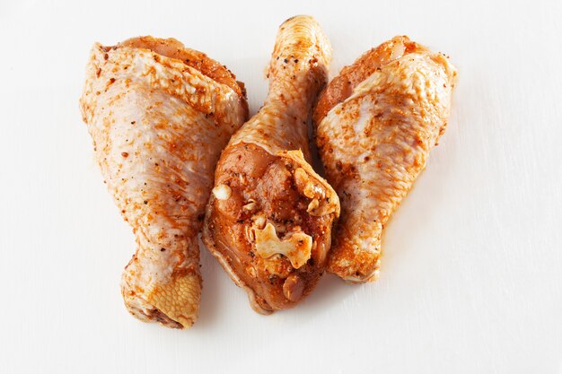 Raw drumsticks on white