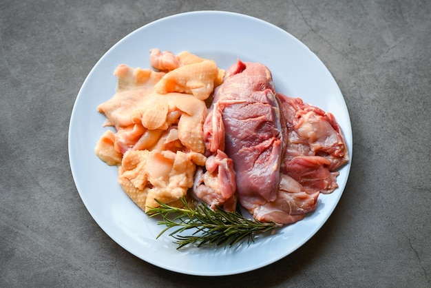 Raw duck breast and duck skin with herb rosemary to cook on plate Fresh duck meat for food