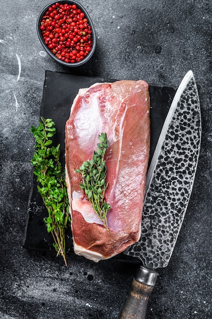 Filetto di petto d'anatra crudo su tavola di marmo. sfondo nero. vista dall'alto.