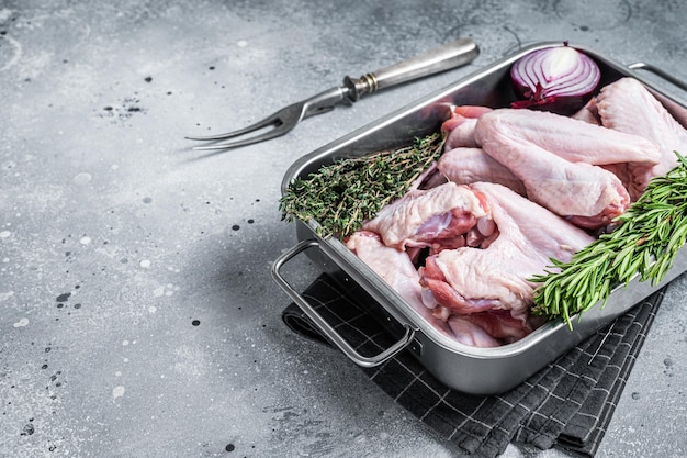 Raw duck wings in a steel tray. Gray background. Top view. Copy space.