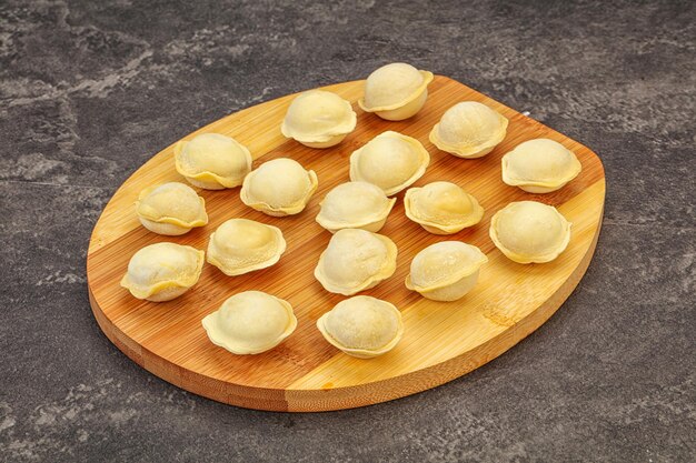 Raw dumplings over board for cooking