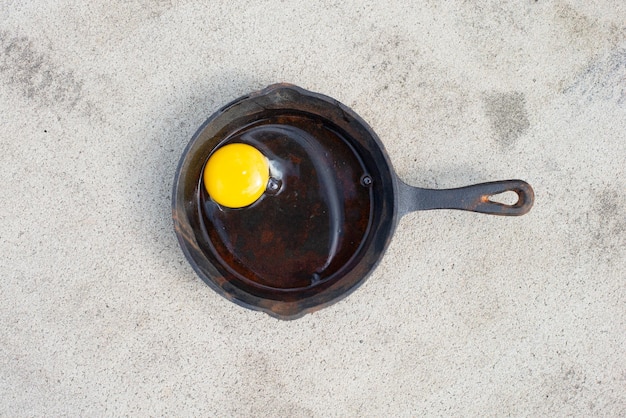 Raw egg frying pan hot asphalt road fried food on sidewalk hot weather concept summer temperature