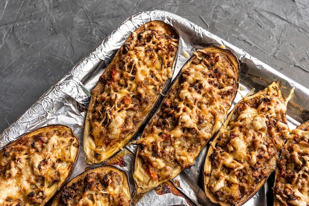 Raw eggplant with meat on a baking sheet