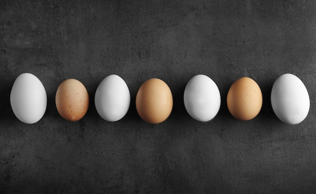 Raw eggs on color background