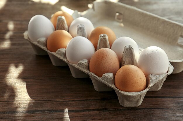 Raw eggs in package on kitchen table