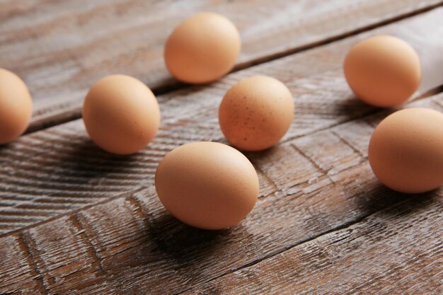 Raw eggs on wooden background closeup