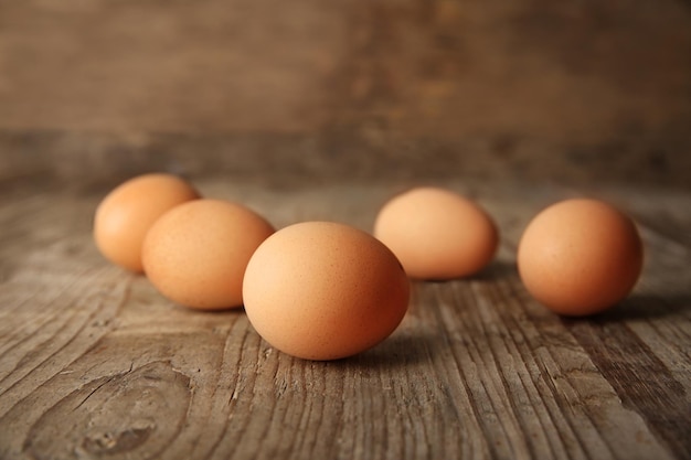 Raw eggs on wooden board closeup