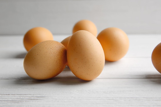 Raw eggs on wooden board closeup