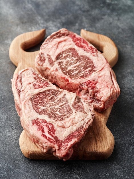 Raw entrecote on a wooden board Fresh marbled beef