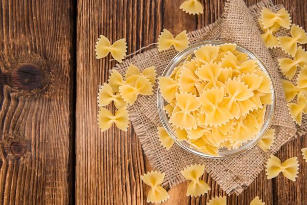 Photo raw farfalle on wooden background