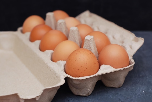 Photo raw farm eggs on a dark blue wooden rustic background food ingredient cooking at home