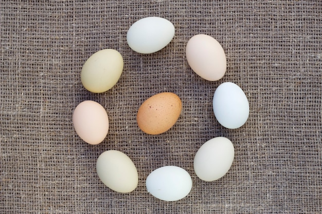 Raw farm eggs on a linen fabric background Traditional food and cooking ingredients