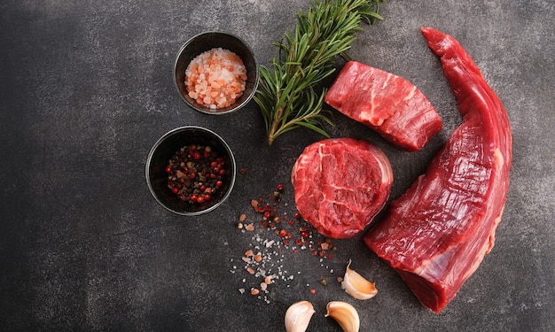 Photo raw filet mignon steaks with herbs and spices, raw fresh marbled meat steak, top view.