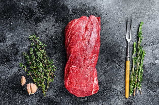 Raw fillet Tenderloin beef meat for steaks with thyme and rosemary.