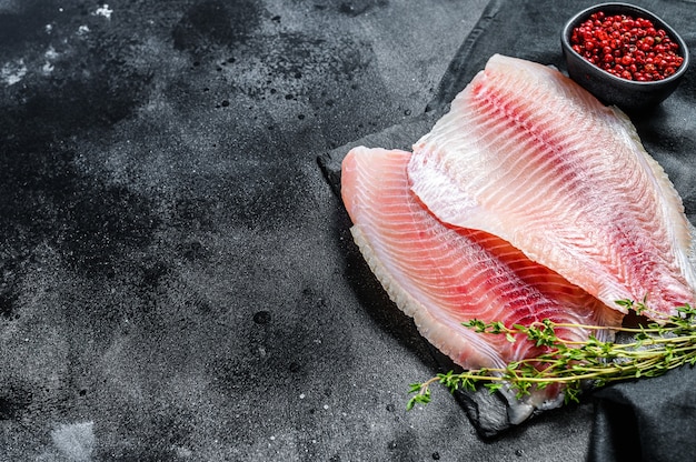 Raw fillet of tilapia on a cutting board