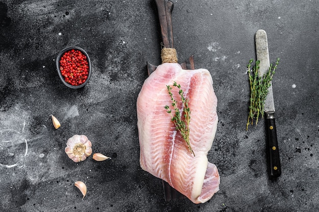 Raw fillet of white fish catfish on a cutting board