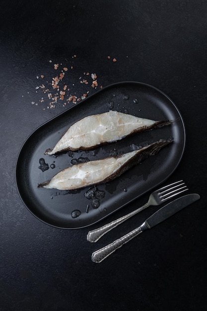 raw fish on a black plate