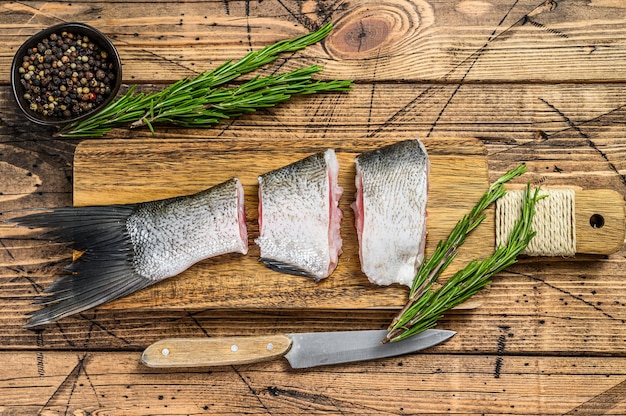 Raw fish silver carp sliced into steaks. wooden background. Top view.