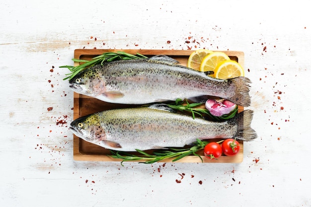 Raw fish on a white wooden background. Fish trout. Top view. Free space for your text.