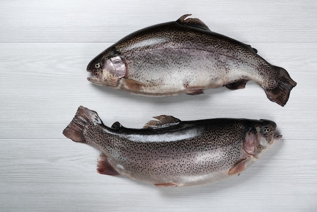 Raw fish on a white wooden background Fish trout Top view Free space for your text