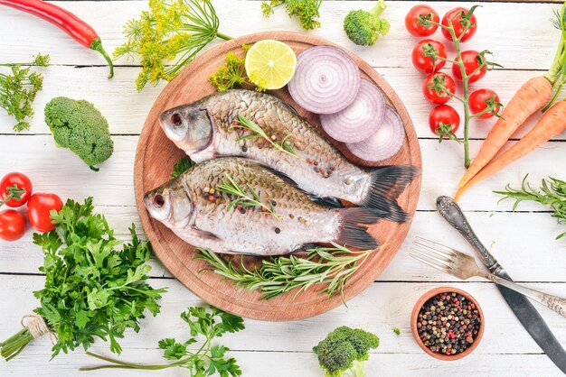 Raw Fish with Spices and Vegetables Carp On a wooden background Top view Copy space