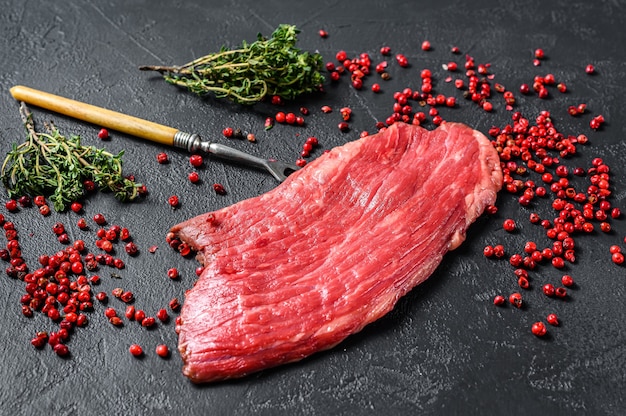 Raw Flank steak with rosemary and pink salt