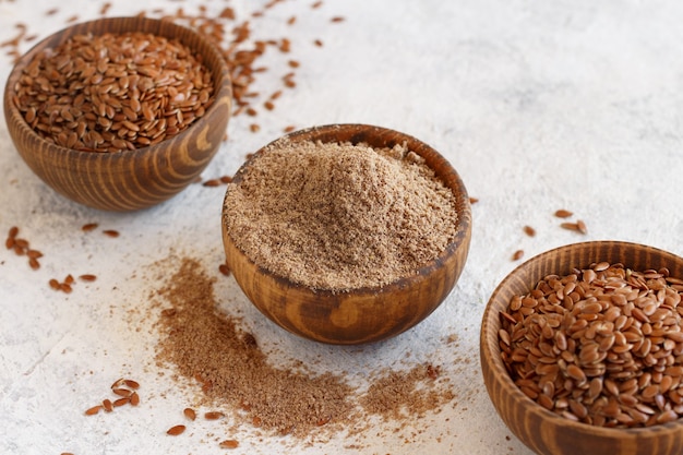 Raw Flax seeds flour and seeds in bowls  close up