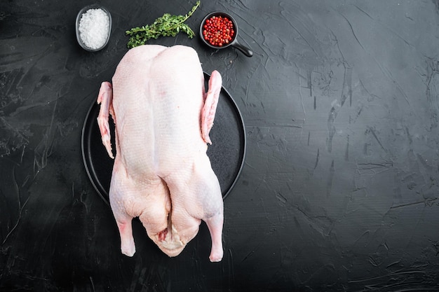 Raw free range goose on black background flat lay with copy space