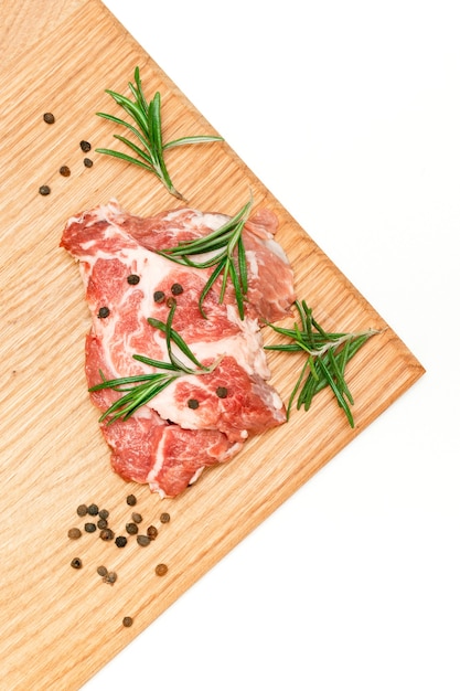 Raw fresh beef meat steak with rosemary and pepper spices on cutting board