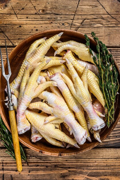 Raw fresh Chicken feets in wooden plate