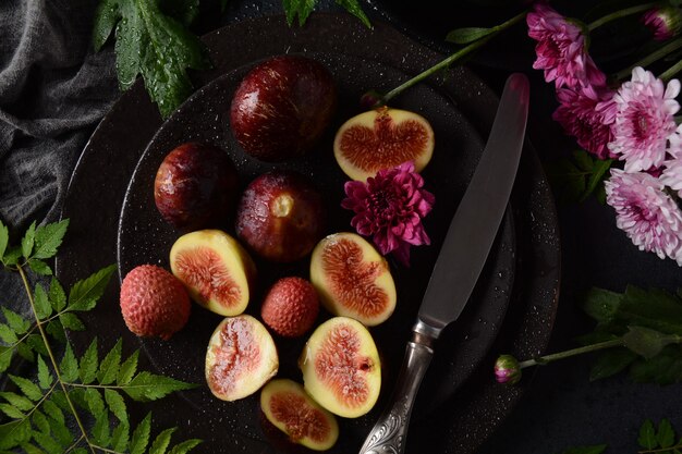 Raw fresh fig fruits on dark background. Slices of fresh common fig (Ficus carica)