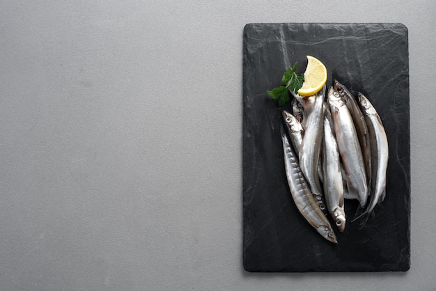 Raw fresh fish capelin gray background top view