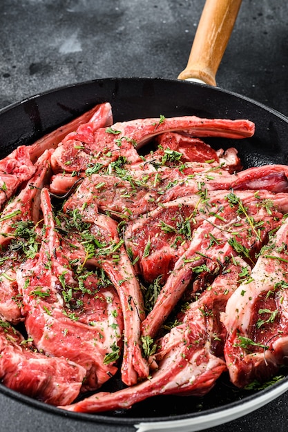 Raw fresh lamb rib chops marinated with thyme and mint in a pan